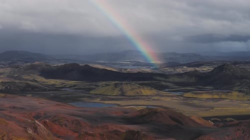 Aerial View of Iceland's Volcanic Terrain with Rainbow and Rivers