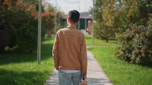 Male Painter Advancing on Leafy Suburban Street with Relaxed Demeanor Creative Man Moving Along