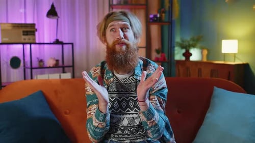 Man Expressing Surprise While Sitting on a Couch