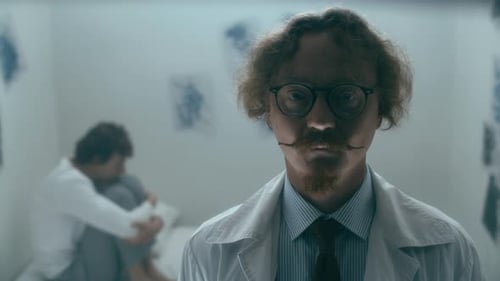 Portrait of Psychiatrist Standing in Ward with Distressed Patient Behind