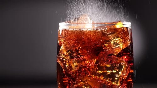 Pouring Soda Over Ice in a Glass