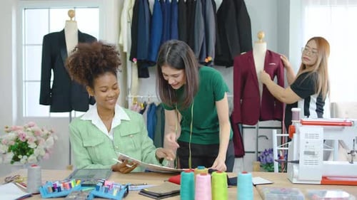 Team of three fashion designers preparation for create new clothes collection in workshop studio