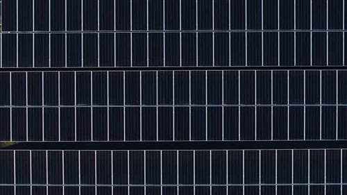 Aerial drone view of solar panels at sunset. Photovoltaics on top of the roof of the building. Alter