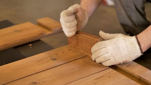 Assemblage de constructions en bois. Le charpentier ajoute une pièce supplémentaire pour aligner les planches de pin thermique. Difficile