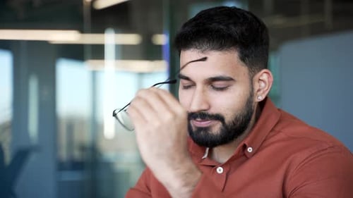 Man Removing Glasses and Rubbing Bridge of Nose