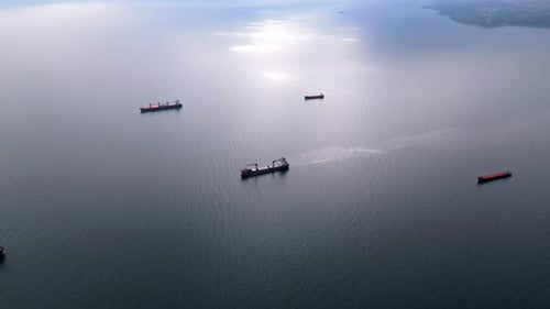 Luftaufnahme mehrerer Frachtschiffe, die über das ruhige offene Meer verstreut sind Die Höhepunkte der maritimen Szene