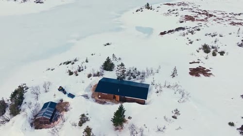 Aerial View Of Mountain Cabin Surrounded By Thick Snow At Winter.