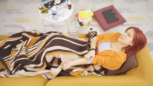 Woman with Itch Lying on Couch Indoors