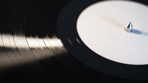 Segmente einer Schallplatte, die sich im Makromodus dreht und Musiktitel vom Plattenspieler abspielt