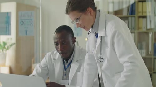 Multiethnic Doctors Working Together on Laptop in Clinic