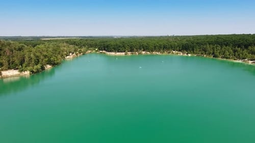 Smooth turquoise surface of water in former quarry. Drone footage over the lake