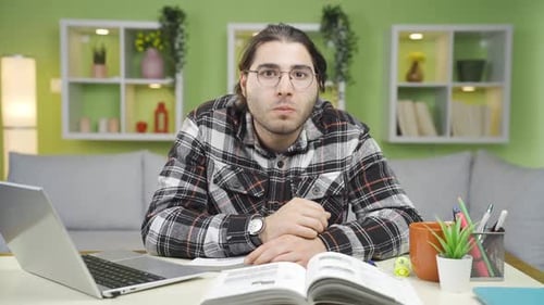 Young Adult Talking Indoors Near Laptop