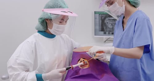 Dentists Perform Dental Procedure in Brightly Lit Office