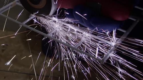 Bright sparks are produced while cutting steel rack with cutting disc