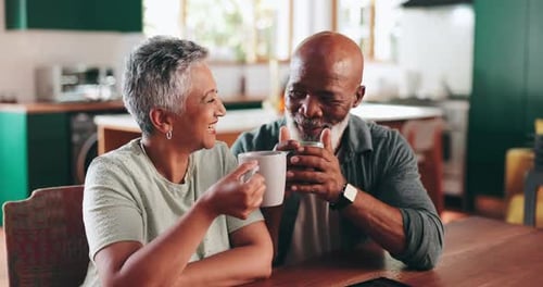 Senior Couple Smiling and Drinking Coffee at Home