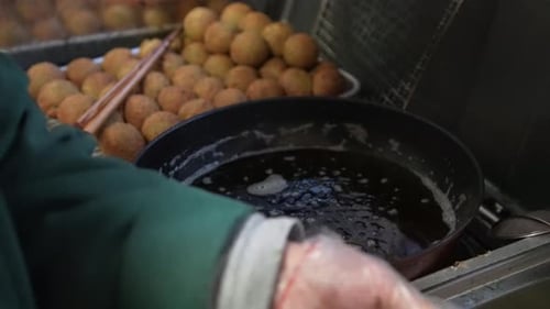 Cook Forms Balls of Dough and Fries Them