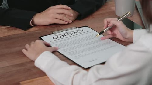 Contract Signing at Business Meeting on Wooden Desk