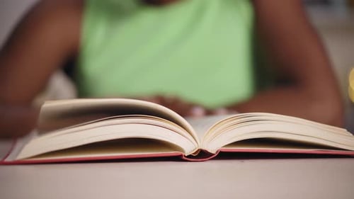 Video Close Up Hands of Young Black Woman at Home Reading a Book Selective Focus on Paperback