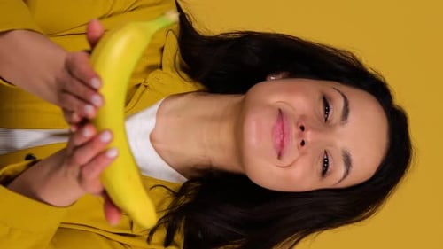 Woman Presents a Ripe Yellow Banana