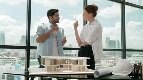 Architects Discussing Model in Office with City View