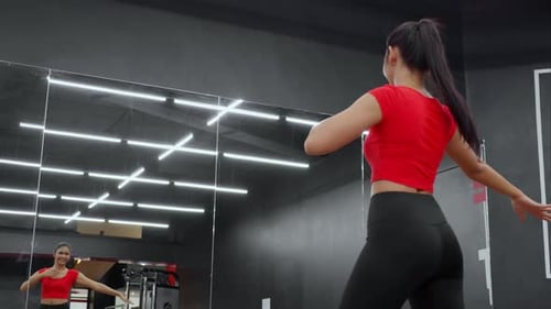 Beautiful young asian woman dancing ballet near mirror for workout with cardio in fitness gym sport.