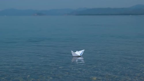 Paper Boat Floating on Blue Ocean Water