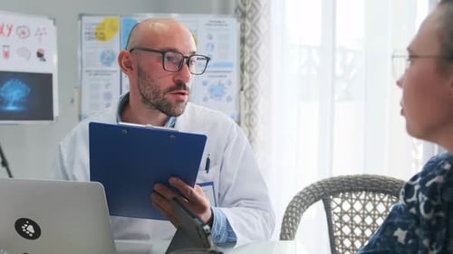 Medical Team Reviewing Report During Meeting in Clinic