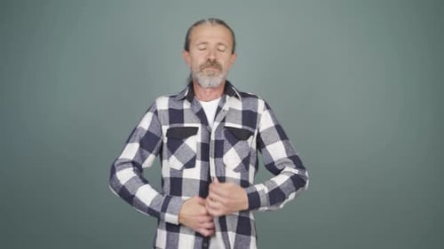 Man Buttons Plaid Shirt in Studio Portrait