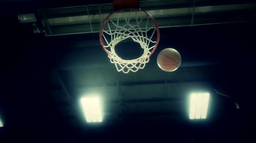 Basketball hitting rim and falling into the net