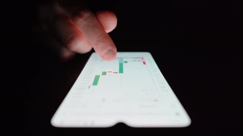 Man browsing candlestick chart on a smartphone. Close up