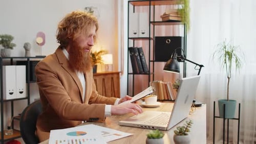 Caucasian Redhead Freelancer Man Accountant Working with Financial Graph Documents Calculate Taxes