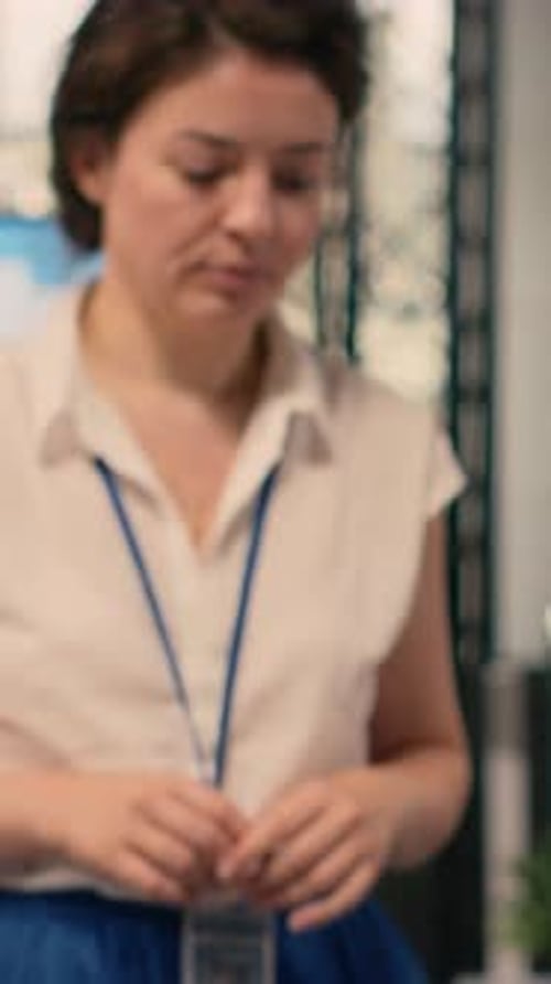 Vertical Video Portrait of Businesswoman Opening Laptop Seated at Office Desk