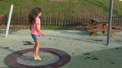 Girl Bouncing on Trampoline at City Playground