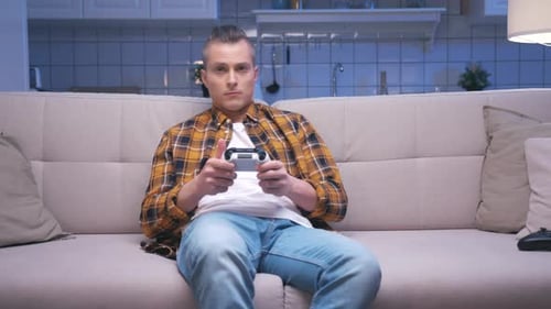Man sitting on couch playing video games