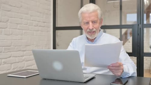 Senior Man Celebrating Success at Work