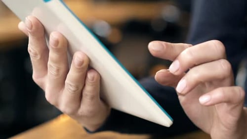Young woman browsing internet on tablet computer in modern cafe