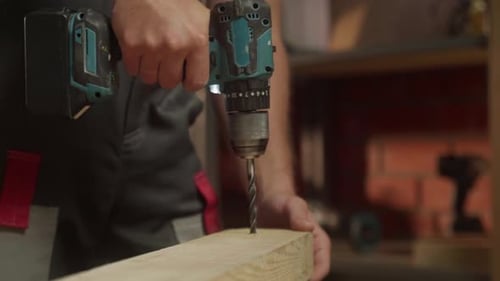 A Person Demonstrates Woodworking Techniques By Using a Power Drill to Create Precise Holes in a