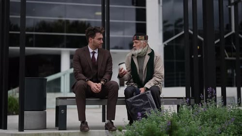 Young Man Talks with Senior Man on Bench