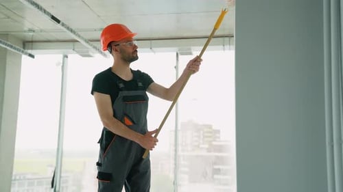 Professional Painter Painting a Wall in Office