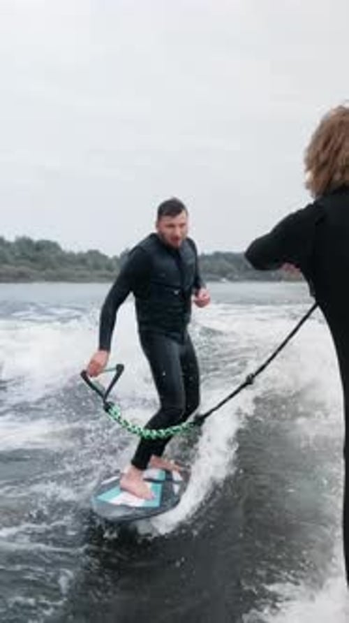 A Thrilling Moment of Wake Surfing A Surfer Riding Waves with Precision and Skill Captured on Camera