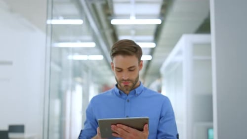 Closeup Serious Business Man Using Tablet in Modern Office. Confident Male Person
