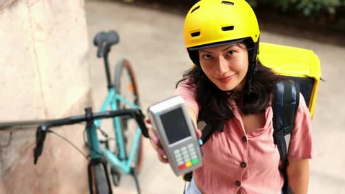 Delivery woman using pos terminal for payment