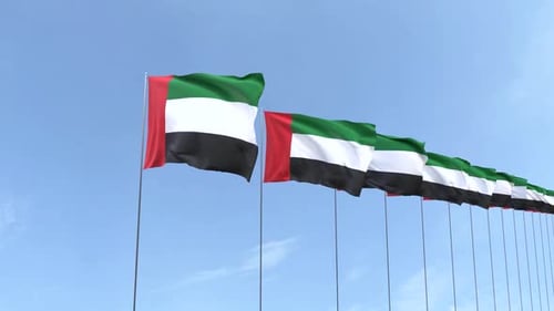 United Arab Emirates Flags Waving in Wind Against Blue Sky
