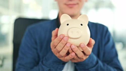Cheerful Man Holds Piggy Bank for Financial Future Savings