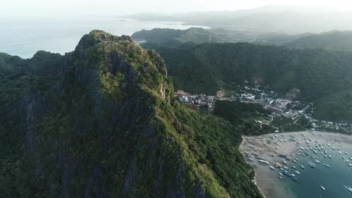 Aerial Drone Shot of High Mountain Covered with Tropical Forest and Boats Anchored in the Bay