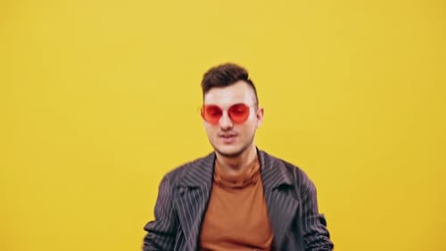 Young Man Dancing Energetically on Yellow Background