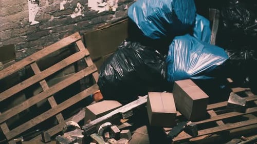 Discarded Waste and Pallets in a Dimly Lit Storage Area During the Day