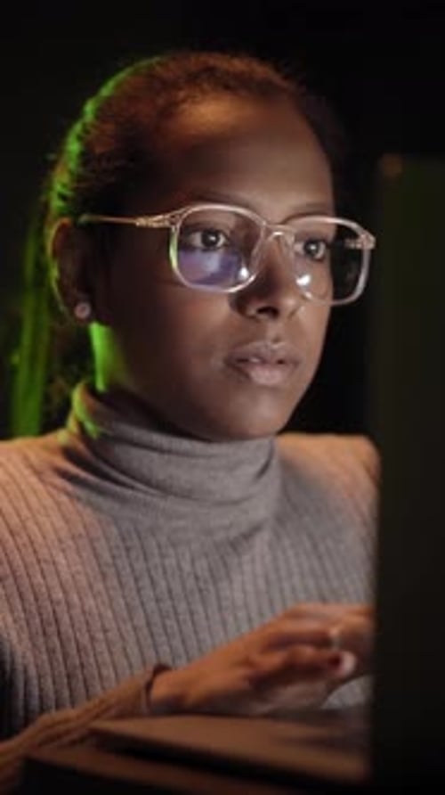 Schöne afrikanische IT-Ingenieurin inspiziert einen sicheren Serverschrank mit moderner Technologie
