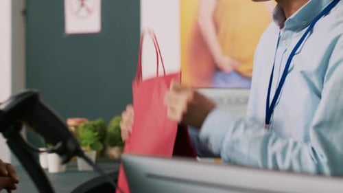 Customer Service Representative Completes Purchase at Counter