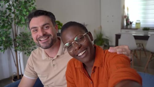 Smiling Couple Waving for Video Call at Home